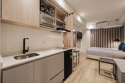 a kitchen with a sink and a bed in a room at Quadrato Studios in Medellín