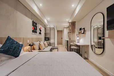 a bedroom with a large bed and a couch at Quadrato Studios in Medellín