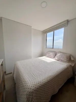 a white bedroom with a bed and a window at Apartamento moderno y acogedor en el corazón de Sabaneta in Sabaneta