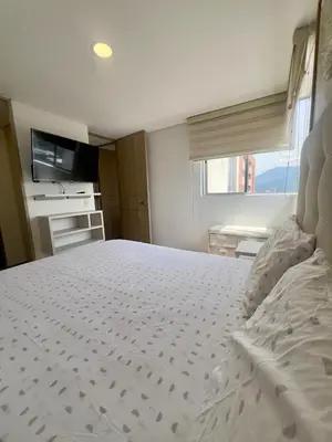 a bedroom with a large white bed with a window at Apartamento moderno y acogedor en el corazón de Sabaneta in Sabaneta