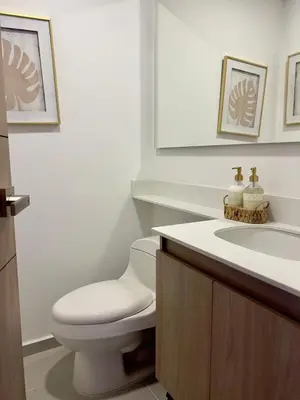 a white bathroom with a toilet and a sink at Apartamento moderno y acogedor en el corazón de Sabaneta in Sabaneta