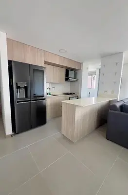 a kitchen with a black refrigerator and a counter at Apartamento moderno y acogedor en el corazón de Sabaneta in Sabaneta