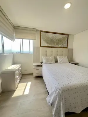 a bedroom with a white bed and some windows at Apartamento moderno y acogedor en el corazón de Sabaneta in Sabaneta