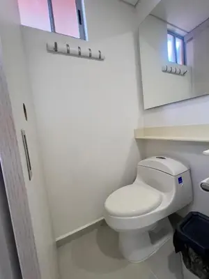 a bathroom with a white toilet and a mirror at Apartamento moderno y acogedor en el corazón de Sabaneta in Sabaneta