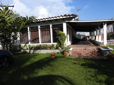 a house with a garage and a grass yard at Finca la Irlanda in Manizales