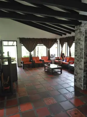 a person sitting on a couch in a living room at Finca la Irlanda in Manizales
