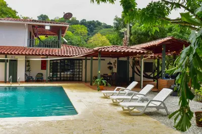 a group of chairs sitting next to a swimming pool at Espectacular finca Familiar en sopetran Antioquia in Sopetran