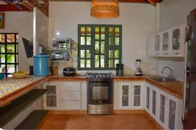 a kitchen with white cabinets and a stove top oven at Espectacular finca Familiar en sopetran Antioquia in Sopetran
