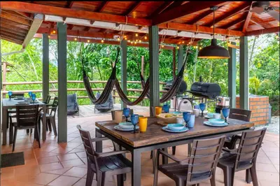 a dining room with a wooden table and chairs at Espectacular finca Familiar en sopetran Antioquia in Sopetran