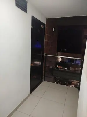 a balcony with a black door and a cage at Apartamento en Belén in Medellín