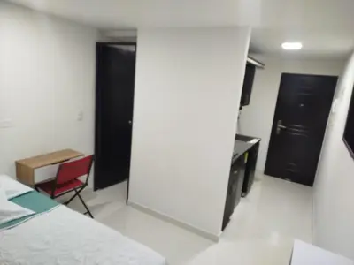 a bedroom with a bed and a desk and a chair at Apartamento en Belén in Medellín