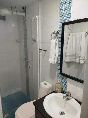 a bathroom with a shower and a sink and a toilet at Apartamento en Belén in Medellín