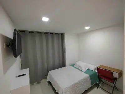 a small bedroom with a bed and a television at Apartamento en Belén in Medellín