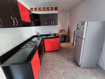 a kitchen with red cabinets and a refrigerator at Augusto Hernandez in Santa Fe de Antioquia