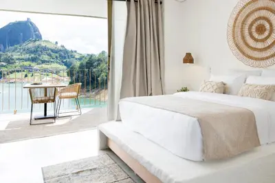 a bedroom with a bed and a large window at MYLOS Hotel Boutique in Guatapé