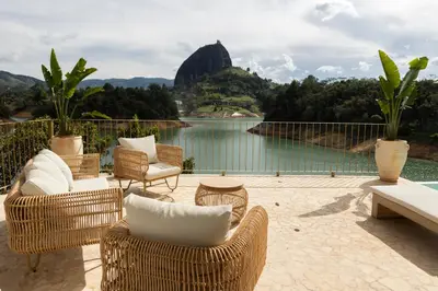 a patio with chairs and a view of a lake at MYLOS Hotel Boutique in Guatapé