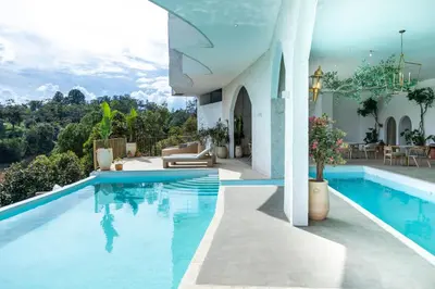 a villa with a swimming pool and a house at MYLOS Hotel Boutique in Guatapé