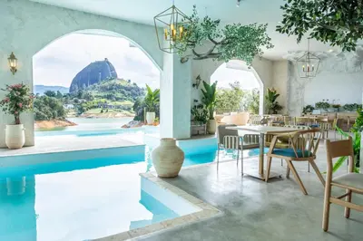 a dining room with a pool and a table and chairs at MYLOS Hotel Boutique in Guatapé