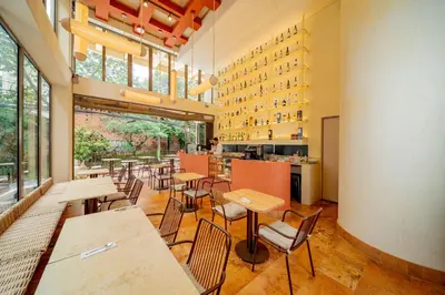 a restaurant with tables and chairs and windows at Moabi Hotel in Medellín