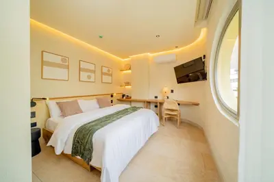 a bedroom with a bed and a desk and a window at Moabi Hotel in Medellín