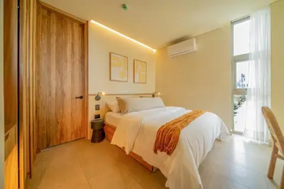 a bedroom with a bed and a large window at Moabi Hotel in Medellín