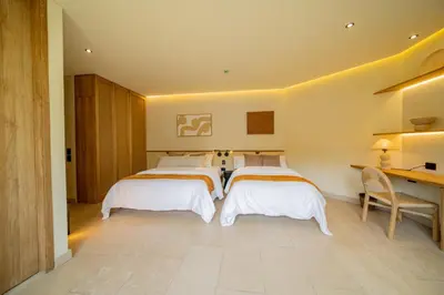 a bedroom with three beds and a desk and a desk at Moabi Hotel in Medellín