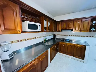 a kitchen with wooden cabinets and a blender at Majana 1 in Jardin