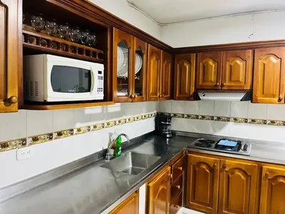 a kitchen with wooden cabinets and a sink and a microwave at Majana 1 in Jardin