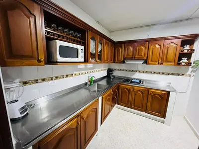 a kitchen with wooden cabinets and a microwave at Majana 1 in Jardin