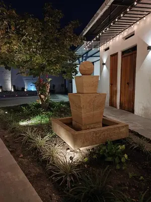 a stone sculpture in front of a building at night at Casa del Cable in Mariquita