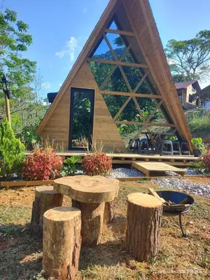 a log cabin with a table and some logs at Glamping Verde Melcocho in San Francisco