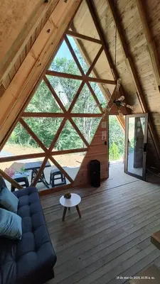 a living room with a large window in a cabin at Glamping Verde Melcocho in San Francisco