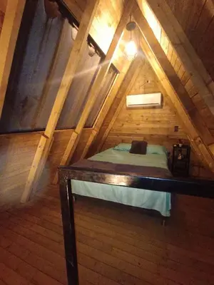 a room with a bed in a wooden attic at Glamping Verde Melcocho in San Francisco