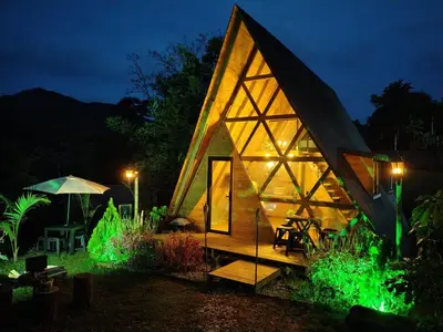 a small house with green lights on it at night at Glamping Verde Melcocho in San Francisco