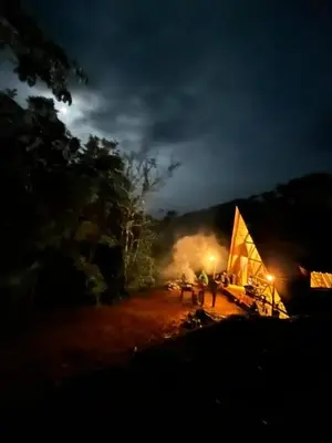 a group of people standing around a tent at night at Glamping Verde Melcocho in San Francisco