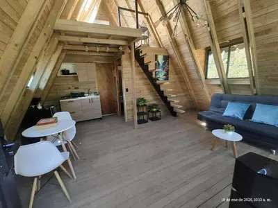 a living room with a couch and tables and a kitchen at Glamping Verde Melcocho in San Francisco