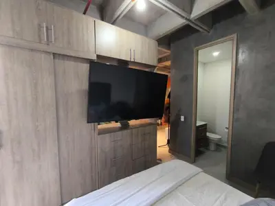 a bedroom with a flat screen tv on a wall at Incleible Apartamento en Sabaneta in Sabaneta