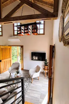 a living room with two chairs and a fireplace at Cabaña Solara in Jardin
