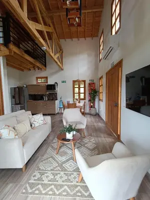 a living room with two white couches and a table at Cabaña Solara in Jardin