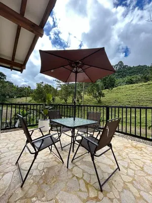 a table and chairs with an umbrella on a patio at Cabaña Solara in Jardin