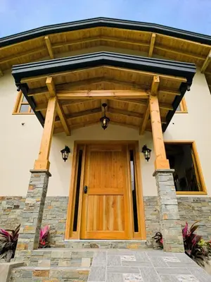a wooden entrance to a house with a wooden door at Cabaña Solara in Jardin