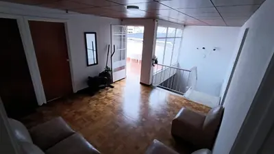 an empty living room with a couch and a hallway at Residencias Universitarias La Casa de Lu sede Estrella in Manizales