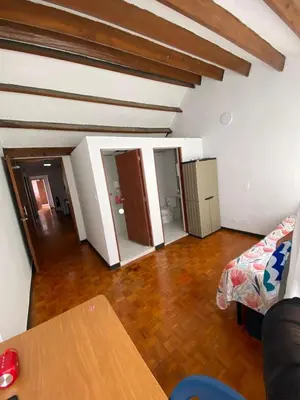 a living room with a bed and a wooden floor at Residencias Universitarias La Casa de Lu sede Estrella in Manizales