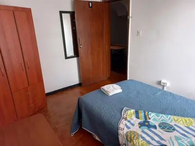 a bedroom with a bed with a blue comforter at Residencias Universitarias La Casa de Lu sede Estrella in Manizales