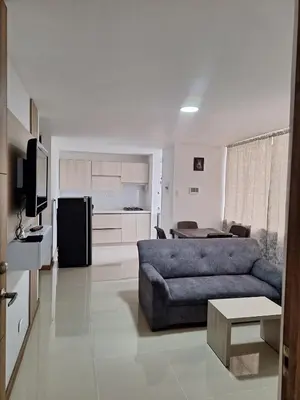 a living room with a blue couch and a kitchen at Apartment FL101 in Manizales