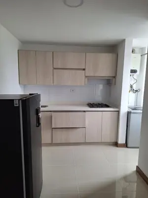 a kitchen with wooden cabinets and a refrigerator at Apartment FL101 in Manizales