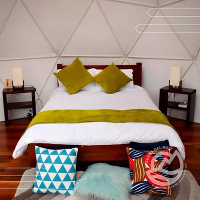 a bedroom with a bed and two night stands at Glamping Reserva del Ruiz in Villamaría