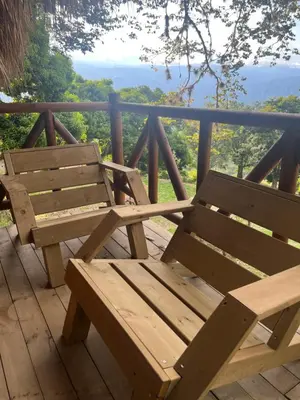 a wooden bench sitting on a deck with a view at Glamping Caribe con bar y bañera privada in Sopetran