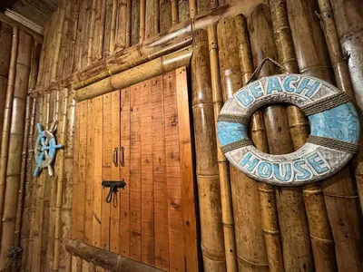 a wooden wall with a welcome to beach house sign on it at Glamping Caribe con bar y bañera privada in Sopetran