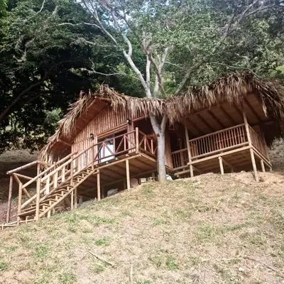 a thatch roofed hut on top of a hill at Glamping Caribe con bar y bañera privada in Sopetran